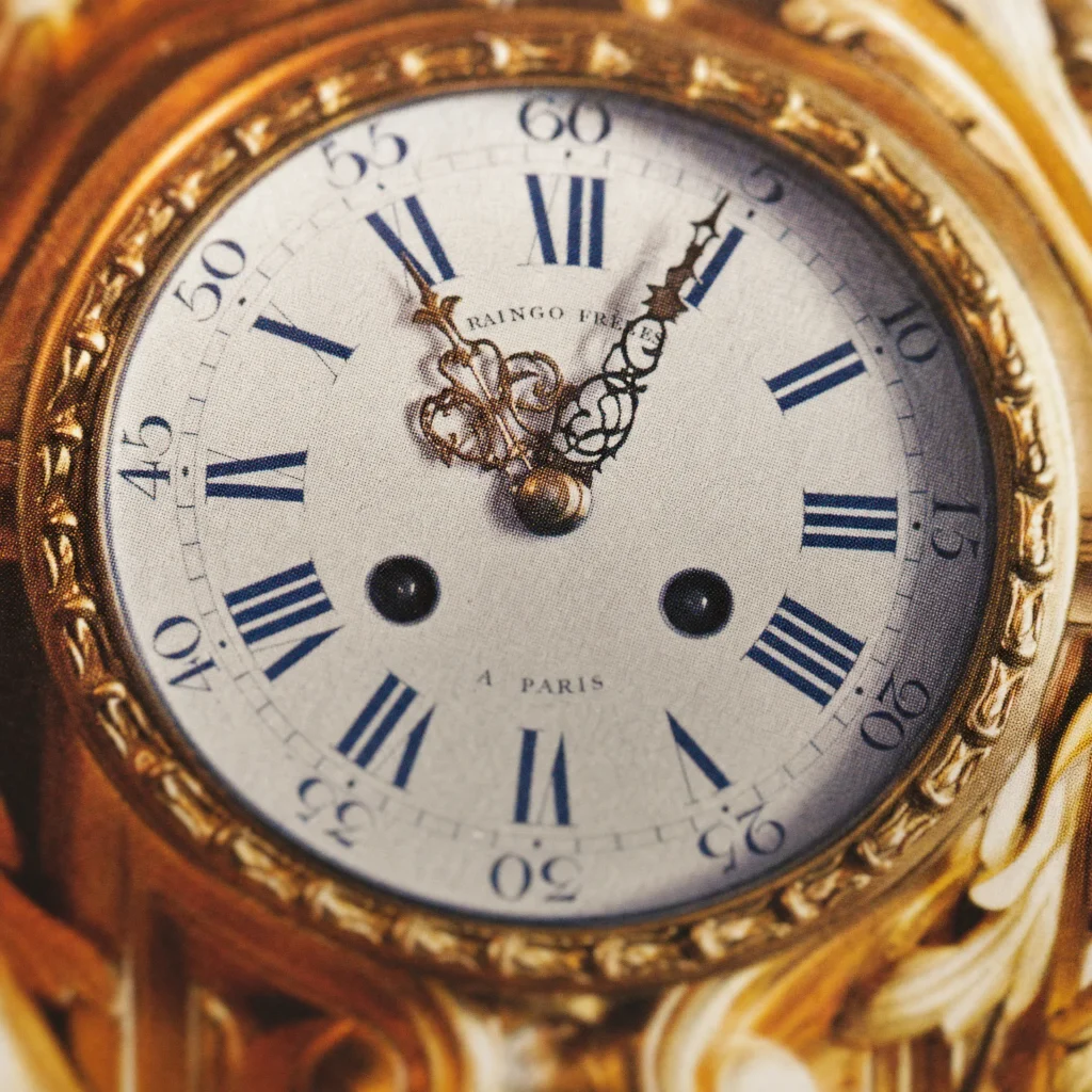 Detalle impreso de la esfera del reloj Raingo Frères de París, con trama de semitono visible en el dorado