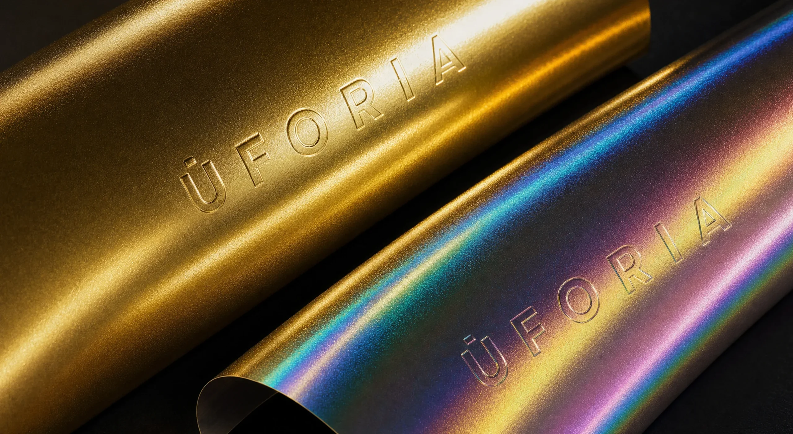 Pruebas de material de Uforia, logotipo gofrado sobre foil dorado y sobre laminado holográfico