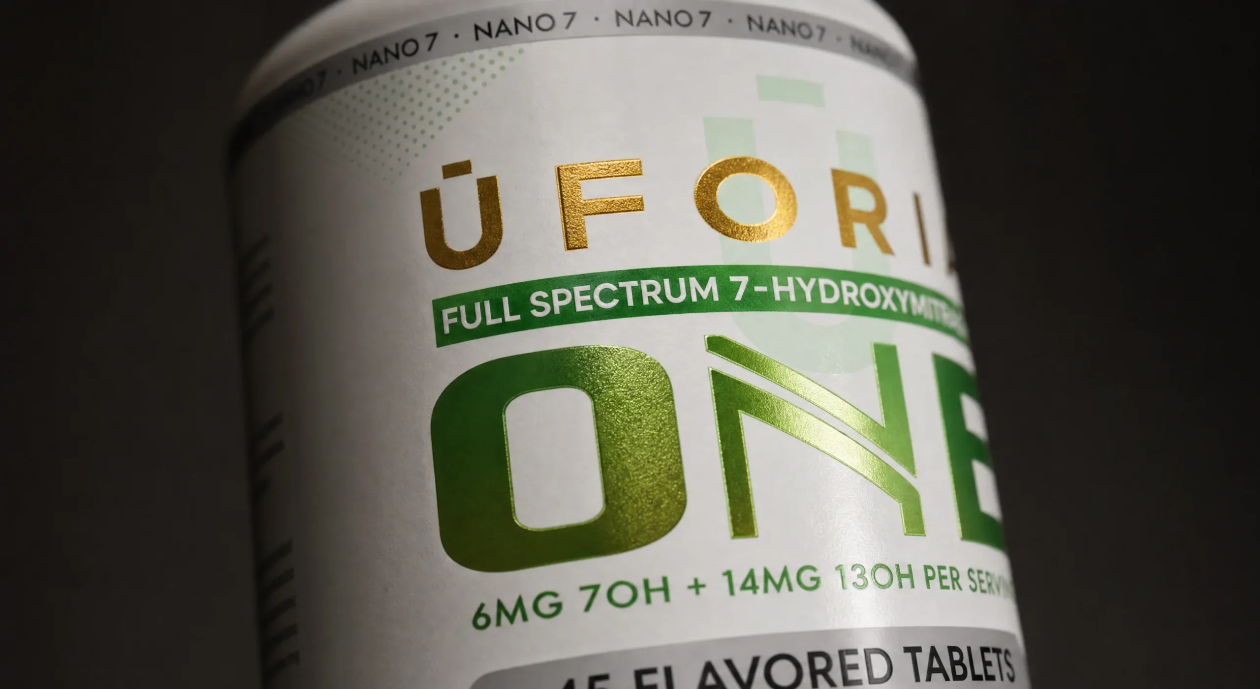 Detalle de bote de Uforia One, logotipo en foil dorado y nombre de producto en foil verde degradado